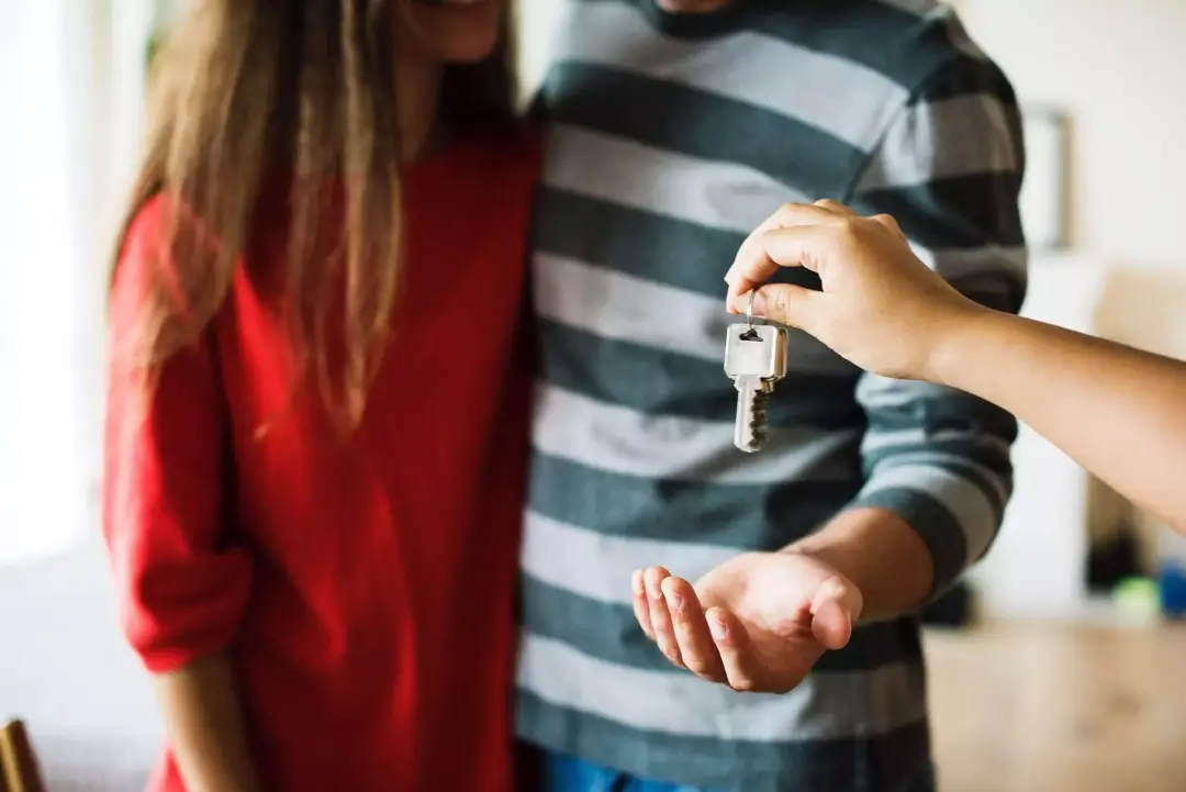 Couple being handed some keys to their new home
